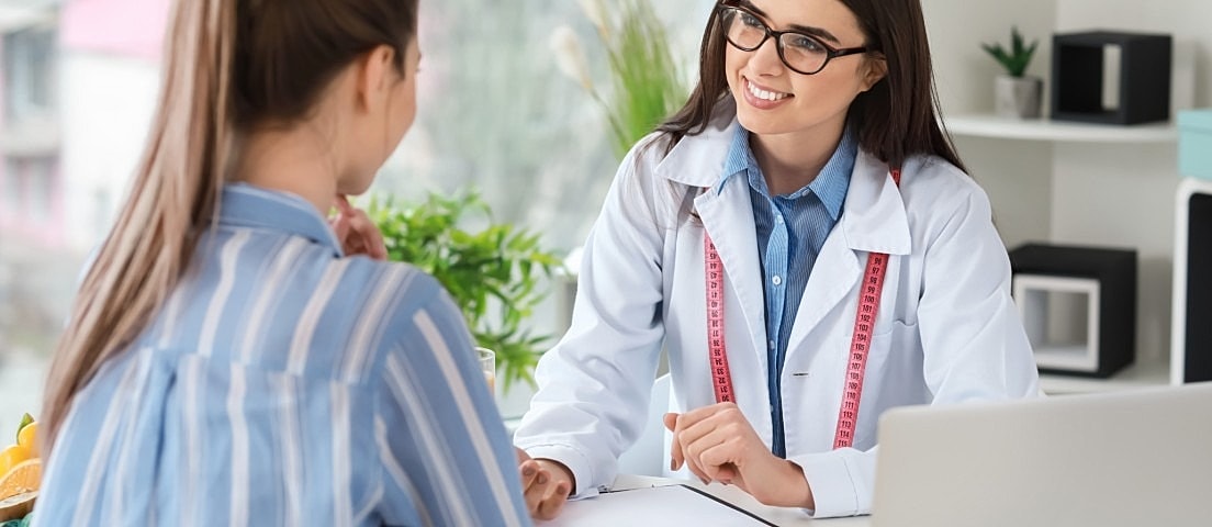 Dietitian consulting with a client in office.
